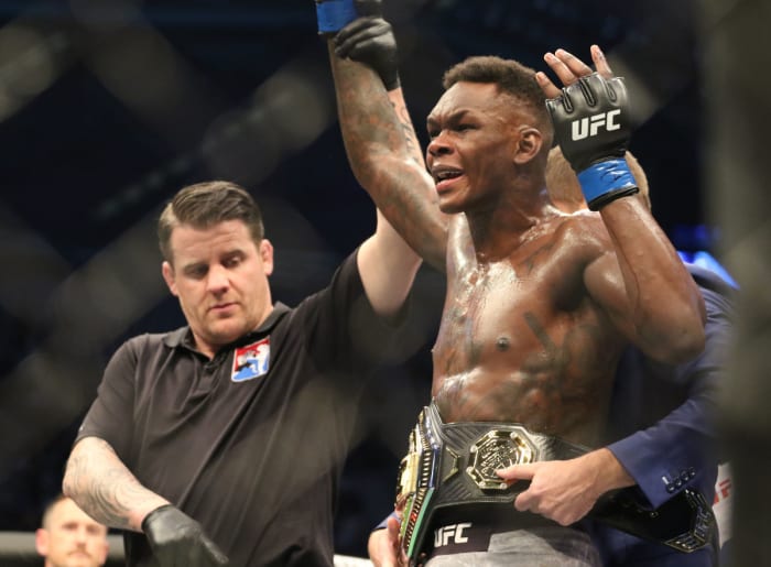 Israel Adesanya (blue gloves) defeats Robert Whittaker (red gloves) during UFC 243 at Marvel Stadium.
